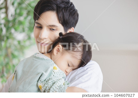 A father holding a child and putting him to sleep 104607027