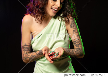 Laughing excited young brunette holding pile of betting chips Laughing excited young brunette holding pile of betting chips 104607518