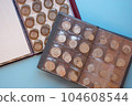 Transparent numismatic coin album, top view of antique coins numismatics collection. 104608544