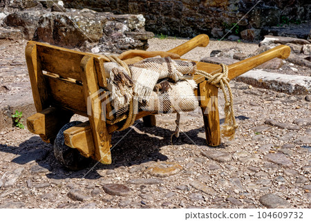 Old-fashioned wheelbarrow - Raglan Castle, Monmouthshire, South Wales Old-fashioned wheelbarrow - Raglan Castle, Monmouthshire, South Wales 104609732