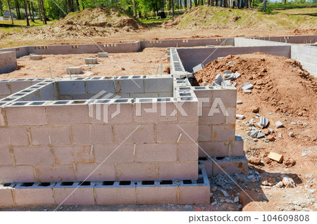 Masonry building foundation of walls in house with dredged soil around Masonry building foundation of walls in house with dredged soil around 104609808