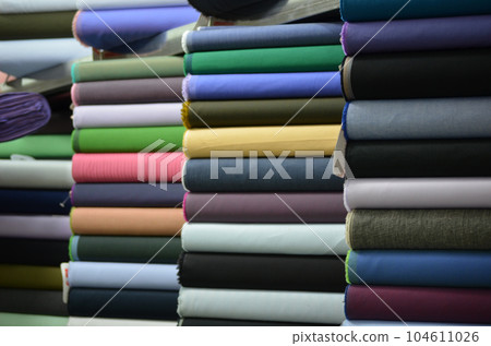 spools of thread, stack of colorful fabrics spools of thread, stack of colorful fabrics 104611026