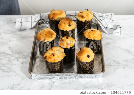 Cooling freshly baked mini Easter bread kulich on a kitchen counter. Cooling freshly baked mini Easter bread kulich on a kitchen counter. 104611779