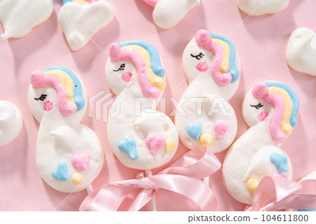 Gourmet unicorn theme meringue pops on a pink background. 104611800