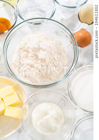 Measured ingredients in glass mixing bowls to make lemon cupcakes. 104611802
