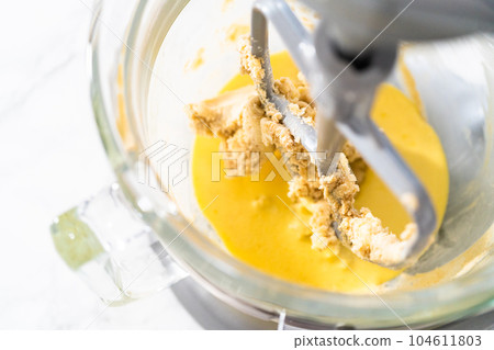 Mixing ingredients in kitchen mixer to bake mini Easter bread kulich. Mixing ingredients in kitchen mixer to bake mini Easter bread kulich. 104611803