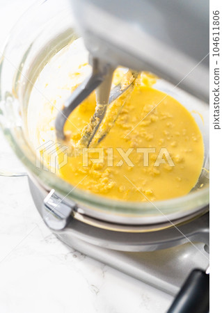 Mixing ingredients in kitchen mixer to bake mini Easter bread kulich. 104611806