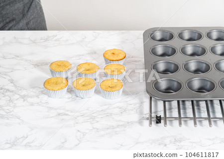 Cooling freshly baked lemon cupcakes on a kitchen counter. Cooling freshly baked lemon cupcakes on a kitchen counter. 104611817