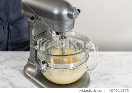 Mixing ingredients in kitchen mixer to bake mini Easter bread kulich. 104611865