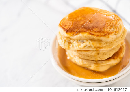 Stack of eggnog pancakes with drizzled eggnog caramel sauce on top. Stack of eggnog pancakes with drizzled eggnog caramel sauce on top. 104612017