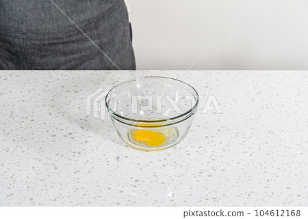 Whisking an egg to make an egg wash for sweet cherry empanadas. 104612168