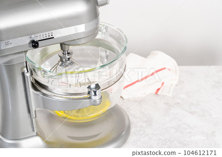 Mixing ingredients in kitchen mixer to prepare unicorn theme meringue pops. Mixing ingredients in kitchen mixer to prepare unicorn theme meringue pops. 104612171