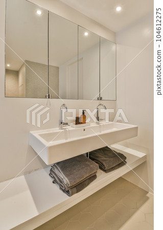 a bathroom with two sinks and mirrors on the wall next to the sink is a towel, towels, and mirror 104612275