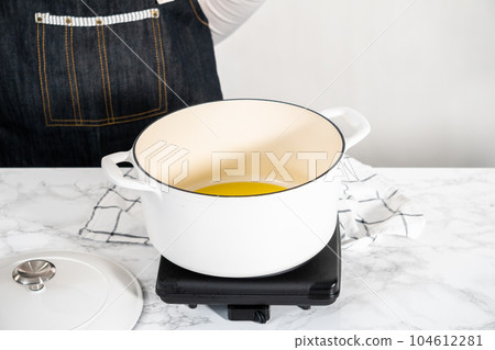 Cooking creamy wild mushroom soup made in an enameled dutch oven. 104612281