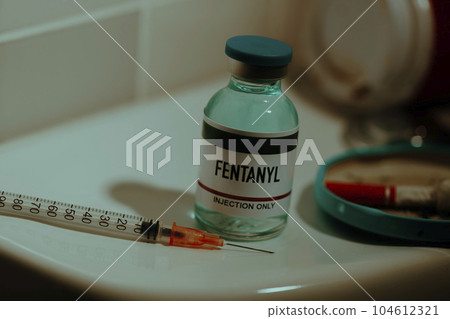 vial of fentanyl and syringe on a toilet 104612321