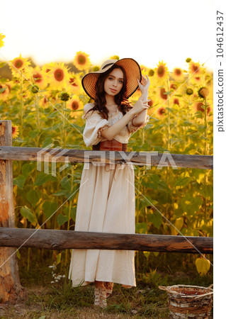 Beautiful woman in a dress in a field of sunflowers Beautiful woman in a dress in a field of sunflowers 104612437