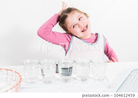 Easter egg coloring. Mixing food coloring with water and a dash of white vinegar to dye Easter eggs. 104612459