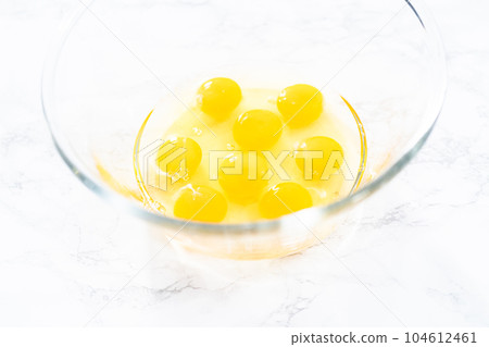 Mixing ingredients in a glass mixing bowl for spinach and ham frittata. 104612461