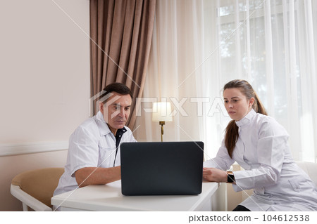 Two doctors man and woman talking, looking at computer screen Two doctors man and woman talking, looking at computer screen 104612538