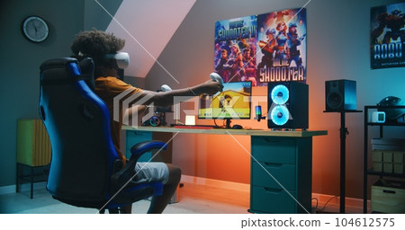 African American teenager in VR headset plays virtual third-person 3D shooter 104612575