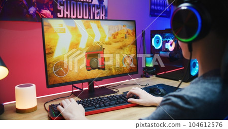 Young gamer plays in car driving simulator on PC 104612576