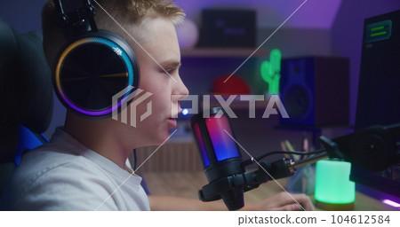 Young gamer plays in third person shooter at home 104612584