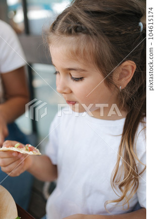 Little girl eating pizza in cafe. Cute girl have lunch after walking in park Little girl eating pizza in cafe. Cute girl have lunch after walking in park 104615174