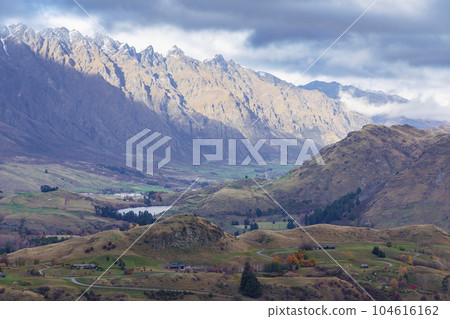 Photograph of a mountain range and large valley in Queenstown on the South Island of New Zealand Photograph of a mountain range and large valley in Queenstown on the South Island of New Zealand 104616162