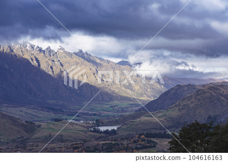 Photograph of a mountain range and large valley in Queenstown on the South Island of New Zealand 104616163