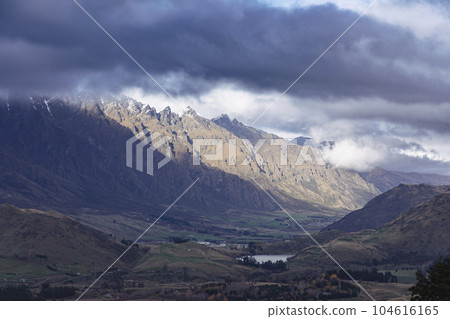 Photograph of a mountain range and large valley in Queenstown on the South Island of New Zealand Photograph of a mountain range and large valley in Queenstown on the South Island of New Zealand 104616165