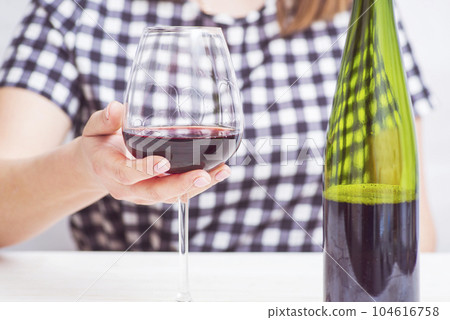 A woman with glass red wine. A woman is drinking red wine A woman with glass red wine. A woman is drinking red wine 104616758