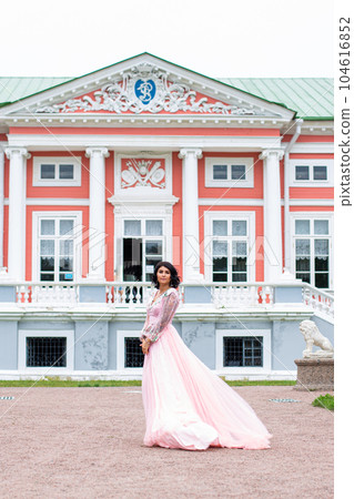 beautiful elegant brunette woman in pink dress  104616852