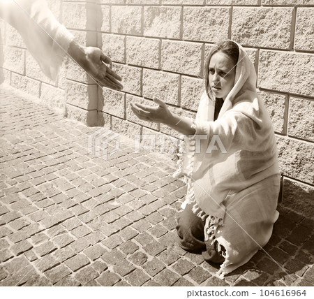 A girl in poor clothes sits on the ground A girl in poor clothes sits on the ground 104616964