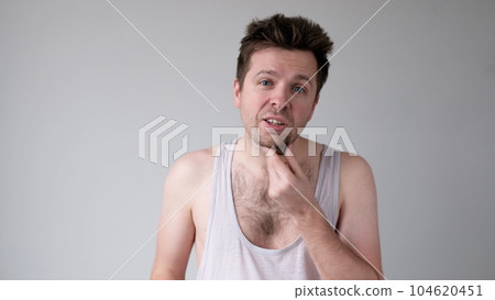 Untidy caucasian man in doubt is scratching his chin 104620451