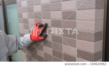 A worker inspecting the outer wall A worker inspecting the outer wall 104620962