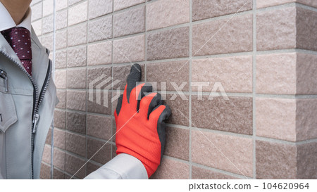 A worker inspecting the outer wall A worker inspecting the outer wall 104620964