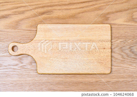 A cutting board made of rubber wood with a feeling of use placed on the table. A cutting board made of rubber wood with a feeling of use placed on the table. 104624068