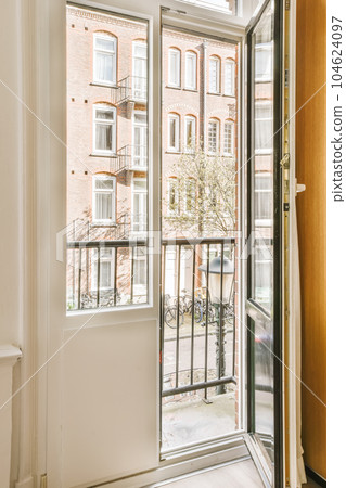 an open door in front of a brick building with two windows, and a bicycle parked on the other side 104624097