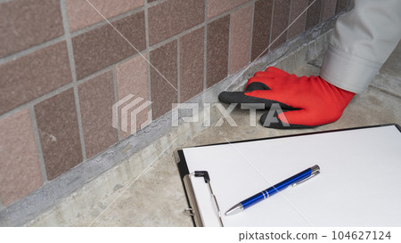 Worker inspecting the deterioration of the outer wall and joints of the apartment | Survey / estimate image Worker inspecting the deterioration of the outer wall and joints of the apartment | Survey / estimate image 104627124
