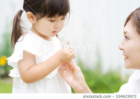 Photo of a parent and child playing in the garden Photo of a parent and child playing in the garden 104629972