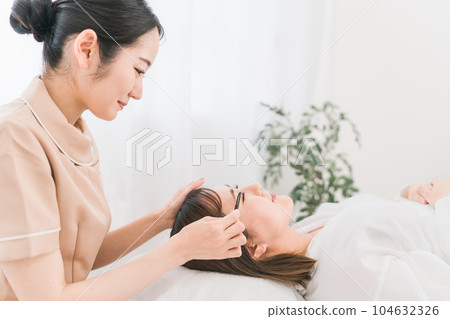 Eyelist performing eyelash extensions 104632326