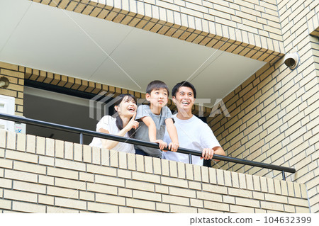 Family looking out from the balcony 104632399