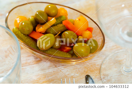 Green olives served with cucumber, carrot, garlic and onion Green olives served with cucumber, carrot, garlic and onion 104633312