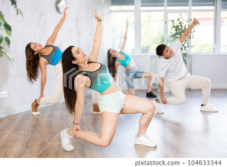 Girl teen perform choreographic exercise and teach energetic house dance with friends 104633344