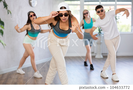 Teenagers boys and girls performing hip hop in studio 104633772