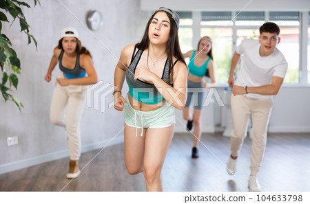 Girl teen perform choreographic exercise and teach energetic mobile social dance vogue with friends 104633798