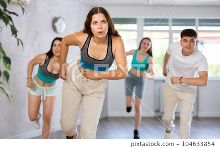 Girl teen perform choreographic exercise and teach energetic waacking dance with friends Girl teen perform choreographic exercise and teach energetic waacking dance with friends 104633854