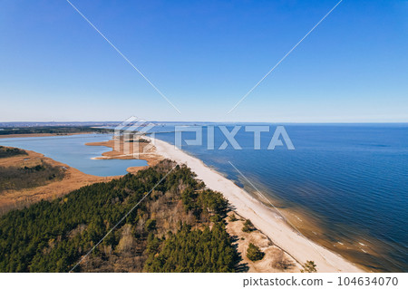 Aerial view drone of river goes into the sea. Delta of Vistula river goes in Baltic Sea in Sobieszewo Gdansk Poland. Forest and small village around 104634070