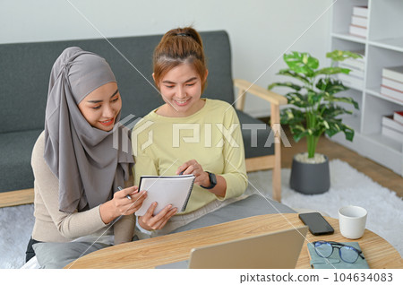 A muslim woman reading with her friend. 104634083