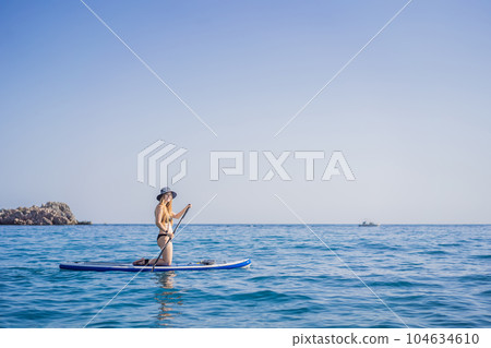 Young women Having Fun Stand Up Paddling in blue water sea near st stefan island in Montenegro. SUP 104634610